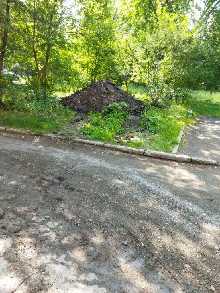 «Привезли и свалили». Снятый асфальт с улицы Октябрьской революции заметили во дворе соседнего дома - В редакцию «Реального Тагила» обратились жители дома, расположенного на перекрестке улиц Газетная и Октябрьской революции. Собственники многоквартирника утверждают, что стали свидетелями, как в вечернее время КАМАЗ груженный землей и кусками асфальта, вывалил содержимое к ним во двор. По их словам, подрядчики, ремонтирующие соседствующую с их домом магистраль, «просто решили таким образом избавиться от ненужных дорожных остатков старого асфальта». Свои слова они подкрепили фотографиями. «Привезли и свалили». Снятый асфальт с улицы Октябрьской революции заметили во дворе соседнего дома -